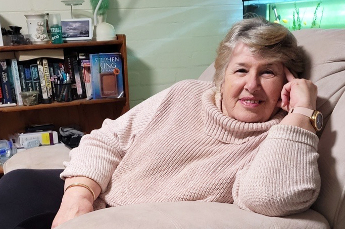 Karen sitting on an armchair inside her rental home